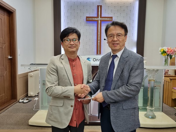 이상대 대표가 포항온누리교회에 성금을 전달하고 있다.
