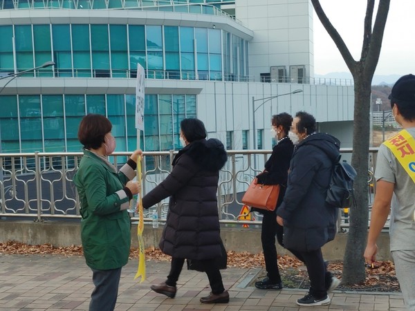 반대집회 시위를 벌이는 신천지 피해자들 사이로 신천지인들이 지나가고 있다.