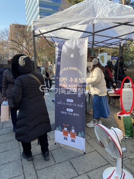 본지에 제보된 광화문역 8번 출구 앞 종교 사기단체 신천지의 홍보부스 사진, 오른쪽에 LPG가스통, 열풍기, 전선이 함께 놓여 있어 위험해 보인다.