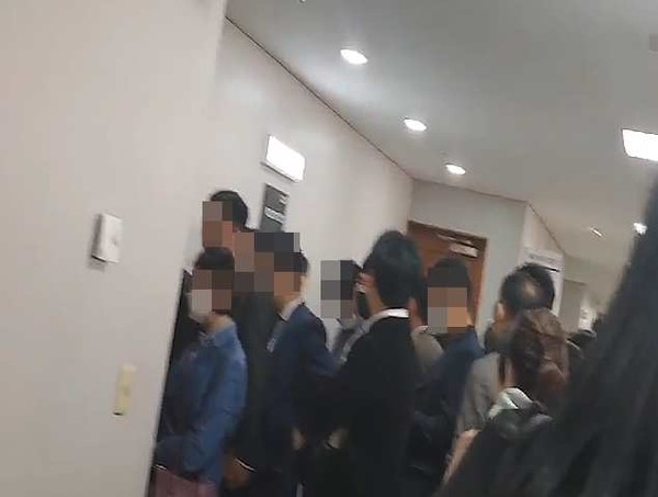 법정 안으로 줄을 서서 진입하는 취재진과 JMS 신도들