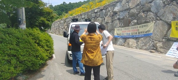 신천지 신도의 차량을 이용한 집회방해에 전피연 회원들과 기자들이 항의하고 있다.